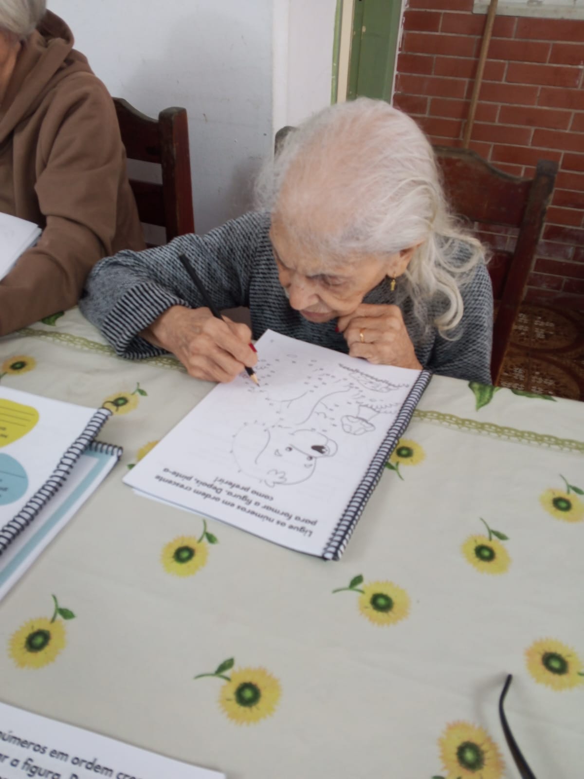 Residente concentrada em atividade com papel e lápis