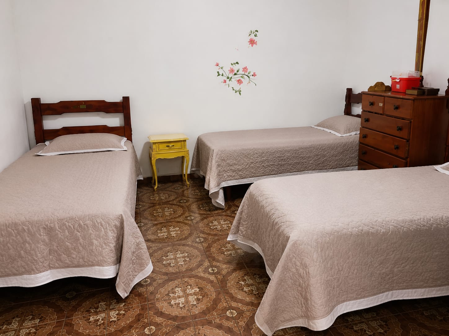 Quarto coletivo organizado com três camas