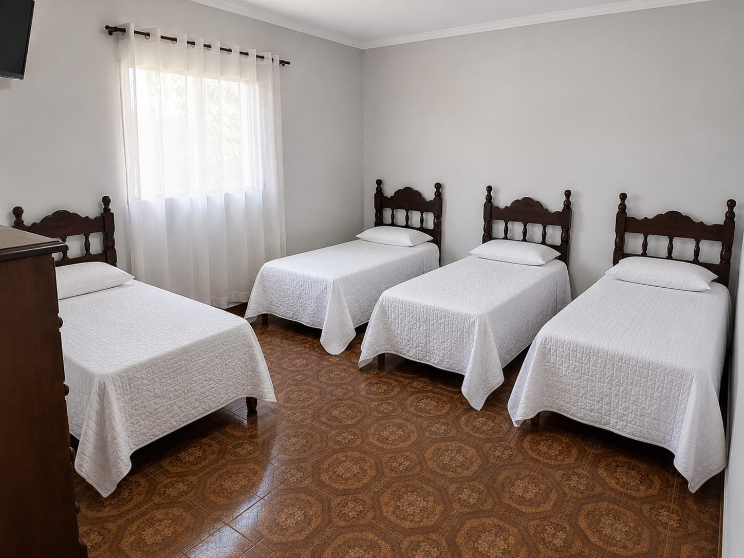 Quarto coletivo claro com quatro camas organizadas